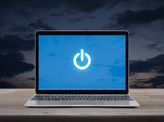 Wall Mural - Power button icon on modern laptop computer on wooden table over sunset sky, Start up business online concept