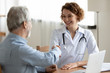 © fizkes - Smiling young female doctor handshaking greeting healthy senior male patient in hospital. Happy practitioner shake hand of elder client at advice meeting. Old people medical health care trust concept.