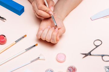 hands of a young girl doing a manicure. the view from the top