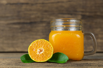 Close up orange cut in half  and a glass of orange juice on wooden table background.