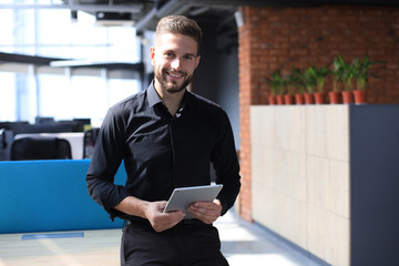 Wall Mural - Handsome businessman using his tablet in the office