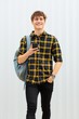 © mimagephotos - happy young man with bag and cellphone by white background