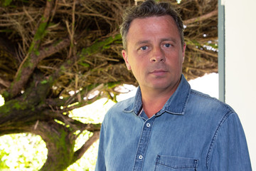 interior handsome portrait of confident middle aged forties man at home window