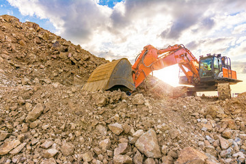 Construction site with an excavator moving rock