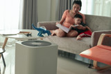Fototapeta Kamienie - air purifier in living room with mother and kid reading inside home