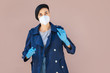 © igishevamaria - Young woman wearing disposable medical mask and gloves on the street during Covid 19 outbreak. Protection in prevention for coronavirus