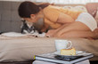 Relaxing woman kissing her dog on sofe with basque burnt cheesecake and coffee on the table.