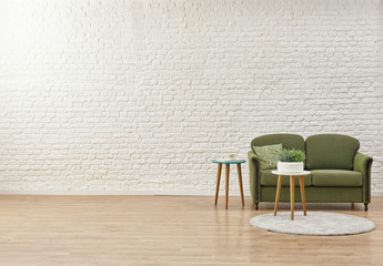 White living room concept, brick detail background and green armchair.