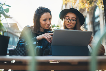 Working business process concept. Freelancer communicate on startup project using digital tablet.  Friends talking in cafe outdoor in sun europe city