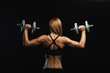 © Georgii - Attractive fitness model with dumbbells posing on a dark background in sportswear. Fitness motivation, beautiful body, achieving goals, blood sweat tears, overcoming oneself.