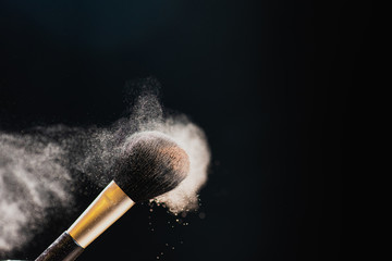 Canvas Print - The art of visage. Closeup photo of professional black makeup brush with colored powder isolated on black background