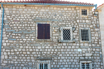 Wall Mural - Authentic house with a stone wall and a beautiful green door and with a beautiful stone bench at the entrance