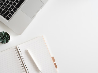 Poster - top view of office desk table with notebook, laptop, plastic plant, smartphone on white background, graphic designer, Creative Designer concept.