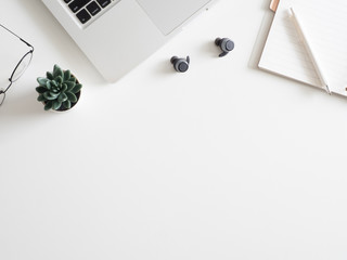 Poster - top view of office desk table with notebook, laptop, plastic plant, smartphone on white background, graphic designer, Creative Designer concept.