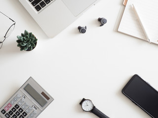 Poster - top view of office desk table with notebook, laptop, plastic plant, smartphone on white background, graphic designer, Creative Designer concept.