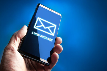 Poster - 1 new message. Phone in the hand of a man. Concept - man received an SMS message. Human received a new message in messenger. Concept - sending SMS messages. An envelope is drawn on the phone screen