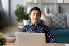Happy Peaceful Millennial Indian Girl Leaning On Chair, Napping, Enjoying Free Break Pause Time At Home. Calm Young Hindu Woman Relaxing With Closed Eyes, Sitting Alone At Desk With Computer.