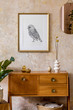 © FollowTheFlow - Retro composition of living room interior with wooden vintage commode, gold pink mirror, mock up poster frame, plant, decoration and elegant personal accessories in wabi sabi home decor.