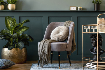 Interior design of luxury living room with stylish armchair, gold liquor cabinet, a lot of plants and elegant personal accessories. Wood panelling with shelf. Modern home decor. Template.