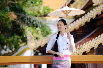 Wall Mural - Northern Thai traditional uniform dress, Portrait of beautiful woman with traditional northern thai dress in temple