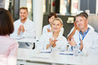 © Robert Kneschke - Doctors in a seminar clap applause