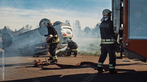 Fotografía Rescue Team of Firefighters Arrive at the Crash, Catastrophe, Fire Site on their Fire Engine