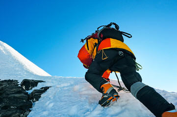 Fototapete - Equipped climber ascent on the top of peak in snowy alpine mountains