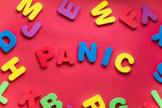 Word PANIC From Plastic Magnetic Letters On Red Background
