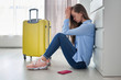 © Goffkein - Frustrated upset woman traveler with yellow suitcase affected by flight delay and cancellation travel and vacation weekends. Travel ban and traveling problems