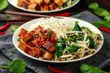 Fried Asian tofu in sweet chilli glaze served with rice, steamed spinach and beansprouts. Vegetable healthy food