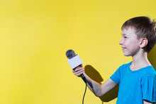 Little Happy Journalist With Microphone Isolated On Yellow Color Background.