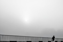Lonely Woman In Fog. Rising Sun In Mist. Black White Photo