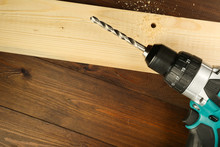  Cordless Drill On Wooden Table With Drilled Hole In Wood Plank Flat Lay With Copy Space