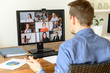 © Vadim Pastuh - Virtual conference with employees. A young man in formal shirt using pc for video call, he has video meeting with several people together. Remote work concept