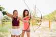 © ManuPadilla - Archery. Two beautiful young women practicing archery in the field. Sport, recreation concept.