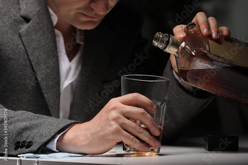 Fotomural A man with bottle of whiskey on the kitchen