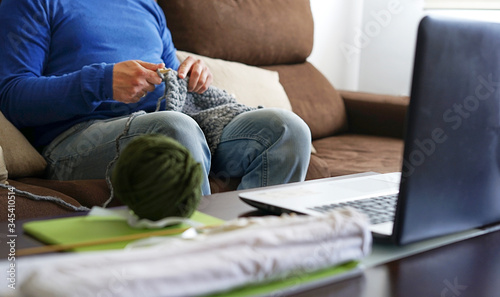 Cuadros en Lienzo Young man watching lesson online and knitting from home