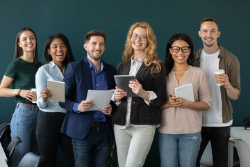 Wall Mural - Portrait of standing in row smiling team looking at camera. Happy diverse corporate staff, young and older specialists, company representatives, bank workers photo shoot, HR agency recruitments.