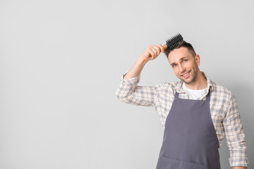 Wall Mural - Male hairdresser on grey background