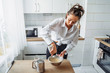 © Daria - Attractive girl preparing dough in a food processor while standing in a bright kitchen. Mixing dough with hand mixer on kitchen table background with cooking ingredients