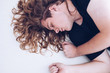 © Magda DJM - view of young man with blond curly long hair, eyes closed lying down