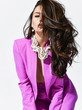 © Dmitry Lobanov - Young beautiful brunette woman in bright purple suit and massive necklace standing and holding naked breast with hand