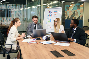 Colleagues having working discussion during meeting in office boardroom. Group of business people working together, successful teamwork concept.