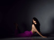 © Dmitry Lobanov - Young beautiful brunette woman in purple trousers and naked upper body and breast lying on floor in sexy pose and stretching