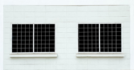 Two windows with black glass on white brick wall background