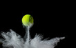 tennis ball on black background. concept photo of chalk dust from hitting the line