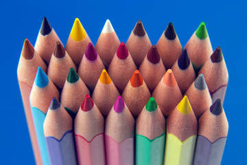 set of color pencils on a blue background. drawing tools. a palette in creativity