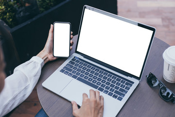 computer,cell phone mockup image blank screen with white background for advertising,hand woman work using laptop texting mobile contact business search information on desk in cafe.marketing,design