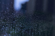 Blurred and focus of rain drop on glass window in monsoon season with blurred building background for abstract and background concept.