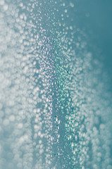 Wall Mural - Blurred and focus of rain drop on glass window in monsoon season for abstract and background concept.